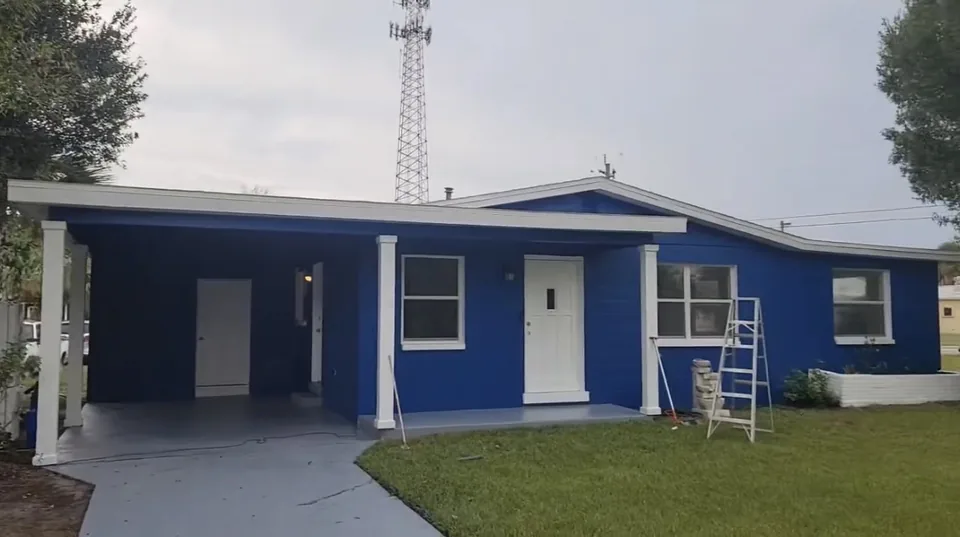 Freshly painted blue single-story home with white columns and carport in Brevard County, FL