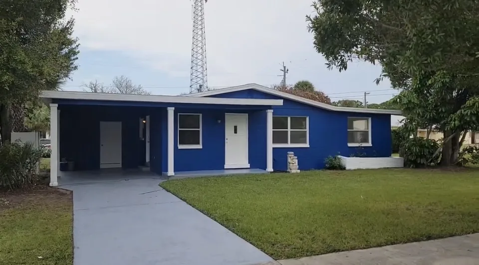 Completed interior and exterior painting with concrete staining on a blue single-story home in Brevard County, FL