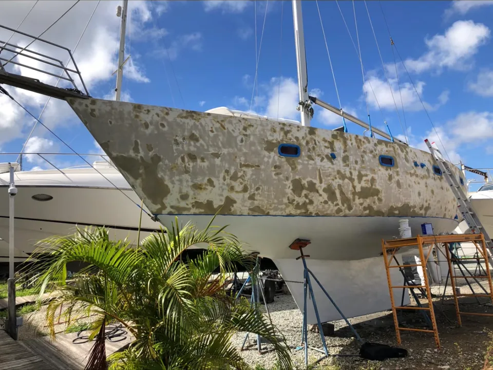 Weathered sailboat hull on stands before repainting in Brevard County, FL