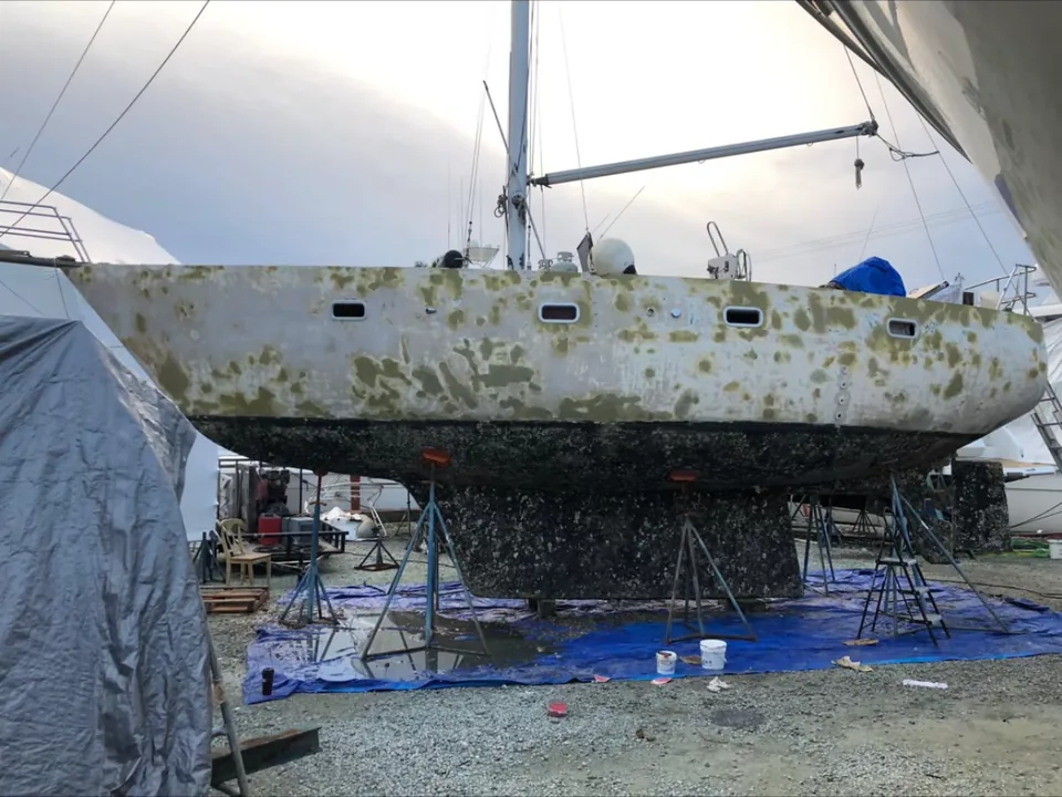 Sailboat hull with heavy oxidation and growth before marine painting in Brevard County, FL