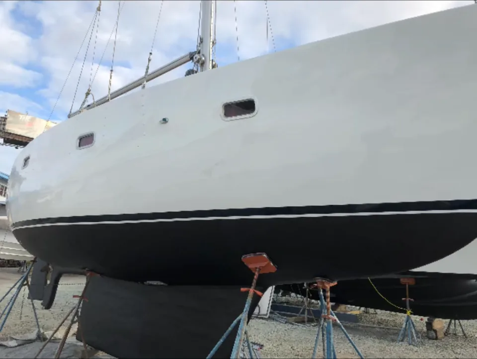 Finished gray sailboat hull with black boot stripe after marine painting in Brevard County, FL