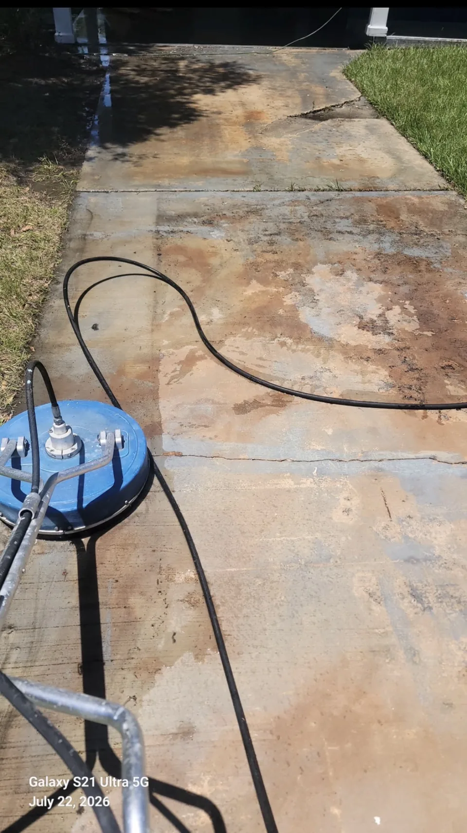 Pressure washing a concrete walkway with a surface cleaner in Brevard County, FL