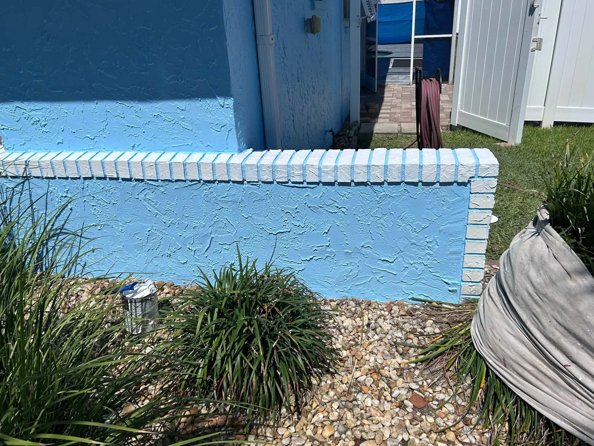 Freshly painted blue stucco garden wall detail in Brevard County, FL by Paint Craft of Brevard