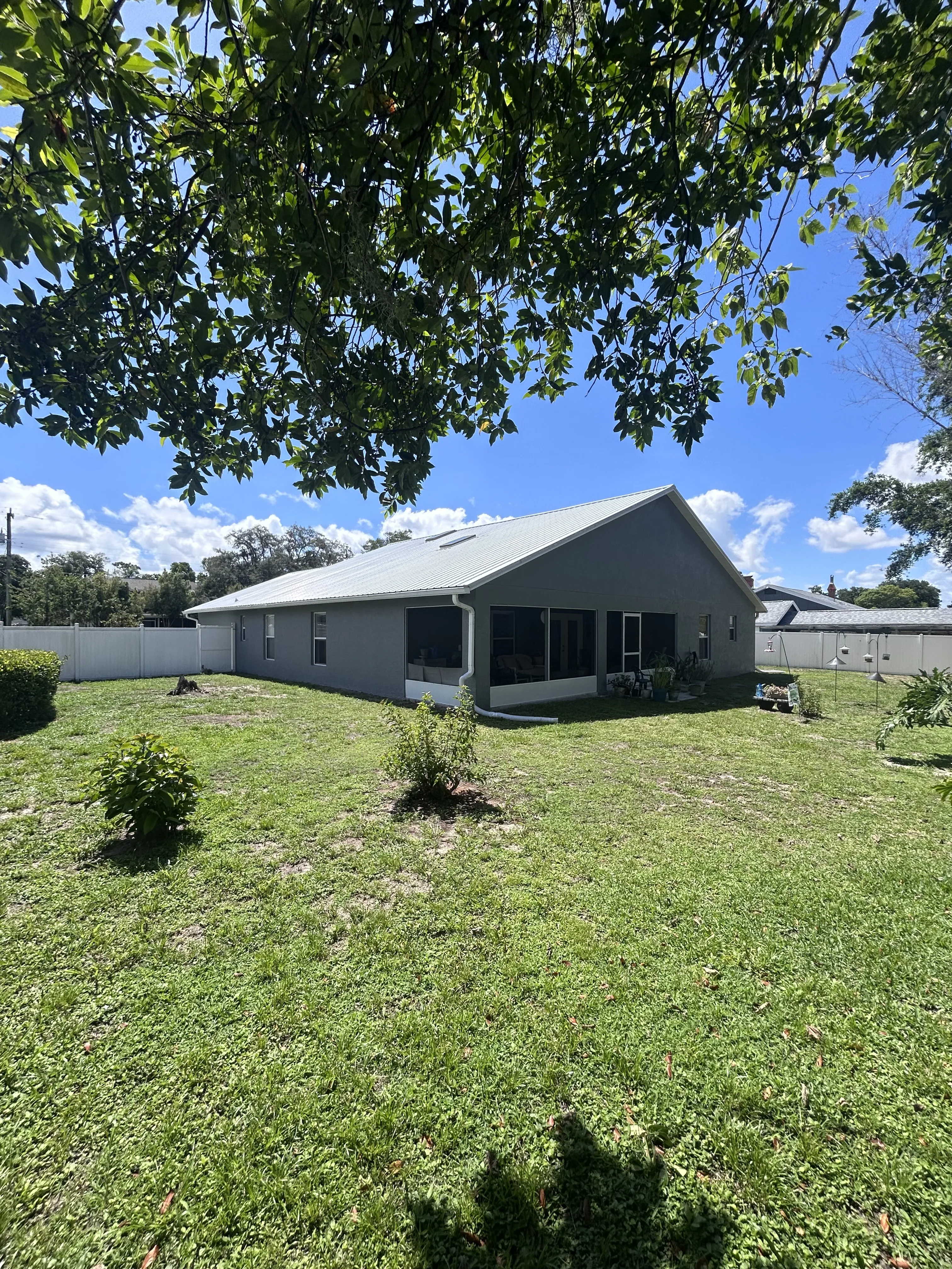 Backyard view of a freshly repainted gray home exterior in Brevard County, FL by Paint Craft of Brevard