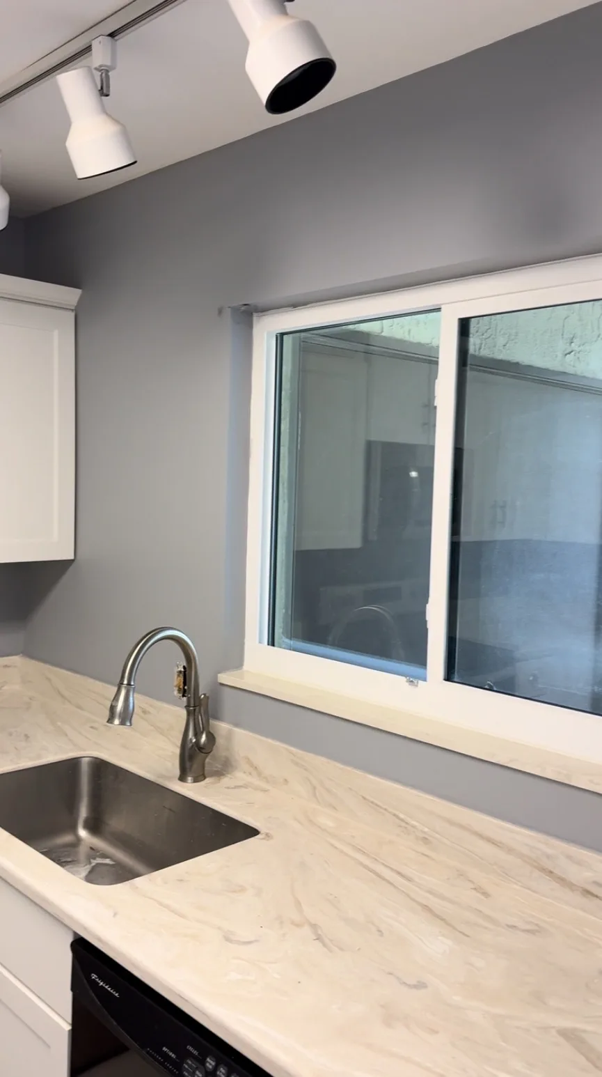 Interior kitchen repaint with gray walls and quartz counters in Brevard County, FL by Paint Craft of Brevard