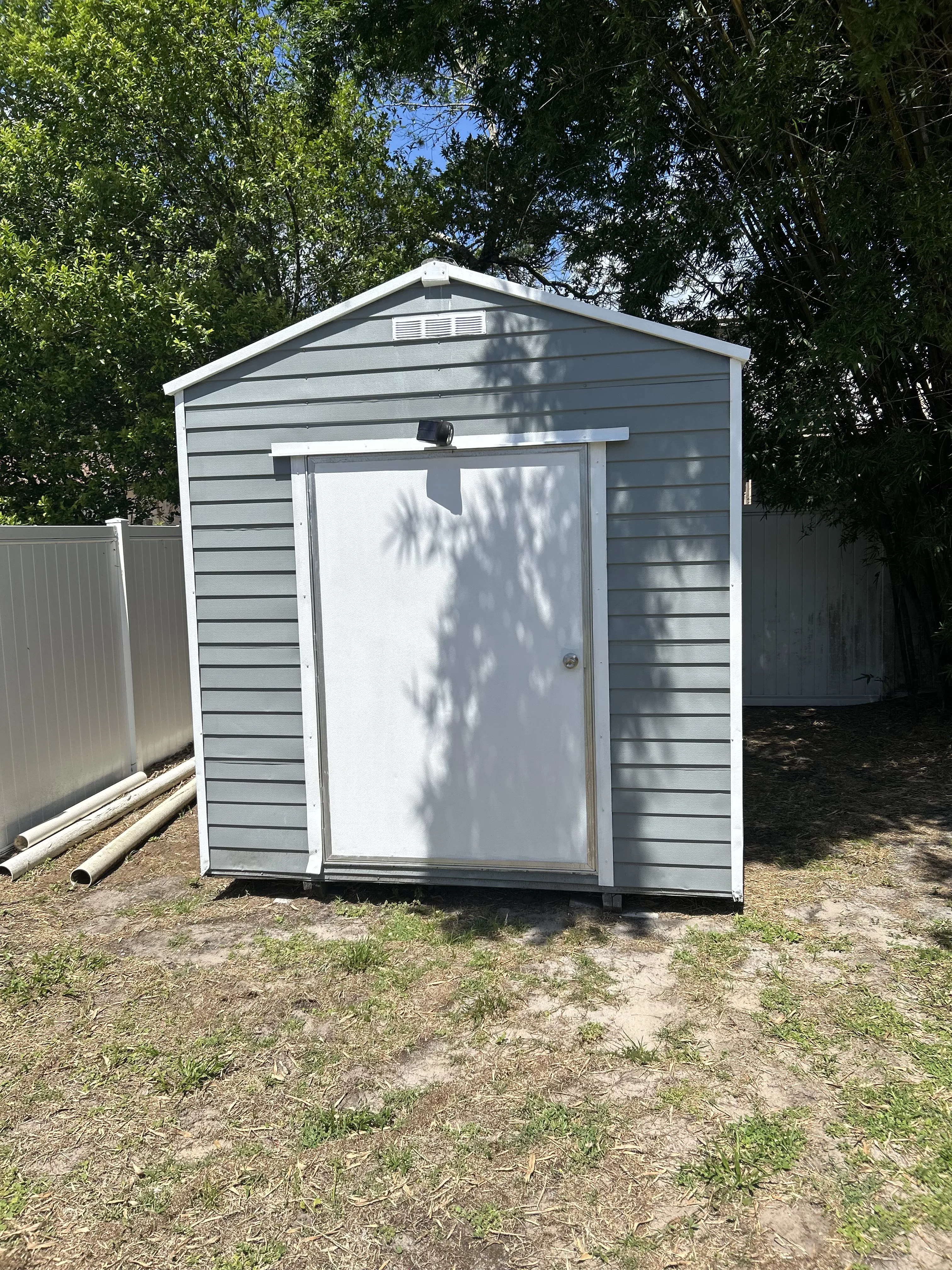 Freshly painted gray storage shed in Brevard County, FL by Paint Craft of Brevard